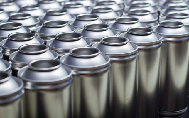 A large number of aerosol cans on a black background